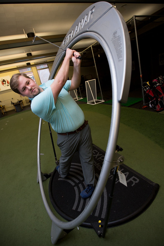 Student uses golf track machine