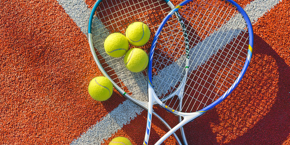 Tennis balls and racket displayed on the court.