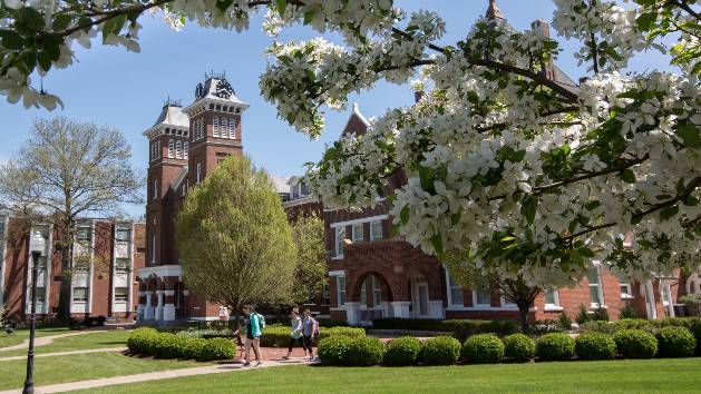 Students walking outside Old Main on a sunny day.